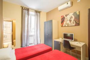 Zimmer mit einem Bett und einem Schreibtisch mit einem Computer in der Unterkunft Hotel Mosaic Central Rome in Rom