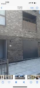 a picture of a brick wall with a garage door at Modern 2bed Sutton in Sutton