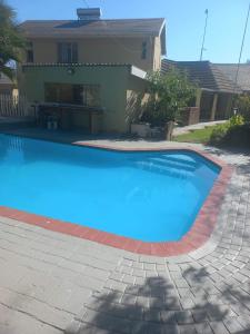 a large blue swimming pool in front of a house at 26 Zea avenue Arcon Park Guest House in Vereeniging