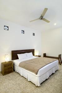 a bedroom with a large bed and a ceiling fan at Teja Home Stay in Ubud