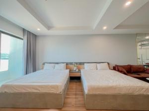 - une chambre avec deux lits et un canapé dans l'établissement TMS Luxury Studio Quy Nhon, à Quy Nhơn