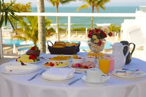 uma mesa com comida com o oceano ao fundo em Itapema Beach Hotéis by Nobile em Itapema
