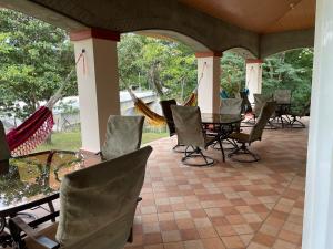 een patio met stoelen, een tafel en een hangmat bij Boca De Los Rios River Site in Penonomé