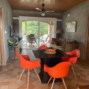 een woonkamer met oranje stoelen en een tafel bij Boca De Los Rios River Site in Penonomé