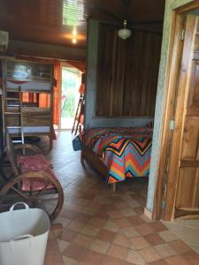 een slaapkamer met een bed en een stoel in een kamer bij Boca De Los Rios River Site in Penonomé