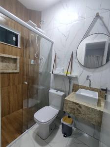a bathroom with a toilet and a shower and a sink at Dunas Residence - Casa 10 in Santo Amaro