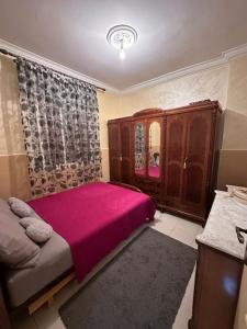una camera con letto rosa e armadio di appartement tanger a Tangeri