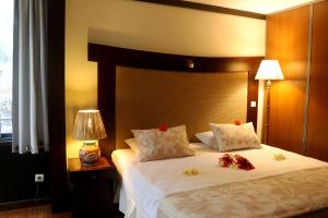 sypialnia z dużym łóżkiem z kwiatami w obiekcie Tahiti Lafayette Beach Lodge w mieście Arue
