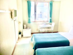 a room with two beds and a table and a window at Hotel Happy Holiday Ishigaki in Ishigaki Island +38 photos