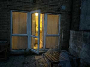 two windows in a brick building with a table and chairs at Stratford Guest House By Cosystays in London