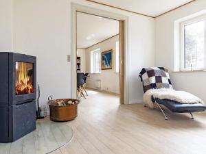 a living room with a fireplace and a chair at Seaside Charm in Gedser - By Traum Ferienwohnungen in Gedser