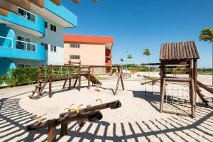 a playground in the sand in front of a building at Arraial Golden Lake Residence in Arraial do Cabo