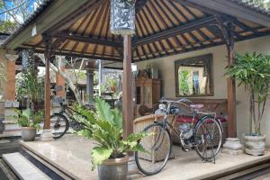 a bike parked in a pavilion with plants at Teja Home Stay in Ubud