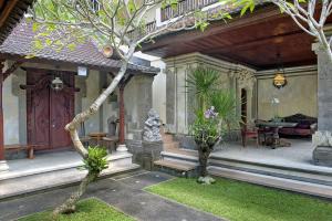 a courtyard of a house with a door and a table at Teja Home Stay in Ubud