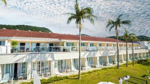 an exterior view of a hotel with palm trees at Itapema Beach Hotéis by Nobile in Itapema