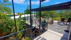 un patio con una terraza con sillas. en Suite Dream Blue en Tamarindo