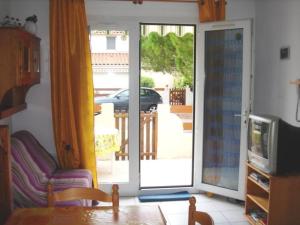 a living room with a door open to a patio at Charmant F2 avec mezzanine, jardinet, terrasse et parking - 4 couchages, Balaruc-les-Bains - FR-1-680-18 in Balaruc-les-Bains
