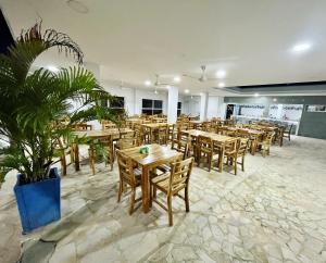 a restaurant with wooden tables and chairs and plants at Hotel Playarena in Coveñas