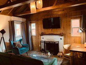 ein Wohnzimmer mit einem Kamin und einem TV an der Wand in der Unterkunft Grand Pine Cabins in Wrightwood