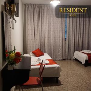 a hotel room with two beds and a sign for a restaurant at Hotel Resident Piura in Piura