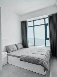 1 dormitorio con 1 cama y ventana grande en SAN Apartment, en Nha Trang