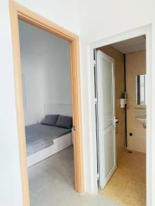 1 dormitorio con 1 cama y puerta corredera de cristal en SAN Apartment, en Nha Trang