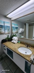 uma casa de banho com um lavatório e um espelho grande em Oceanfront Efficiency T508 em Myrtle Beach