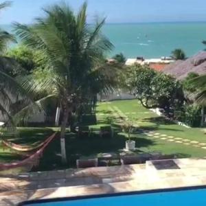 a view of a resort with palm trees and the ocean at Pousada Vale do Luar in Canoa Quebrada
