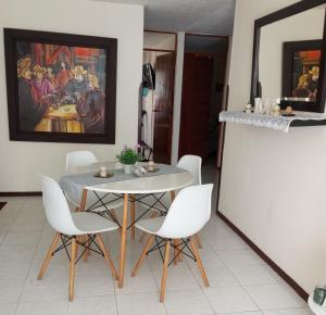a dining room with a table and white chairs at Habitación Conj parque San Agustín, Floridablanca in Floridablanca