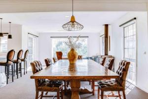 une salle à manger avec une grande table et des chaises en bois dans l'établissement Heritage Holiday House No.17, à Wonga Park