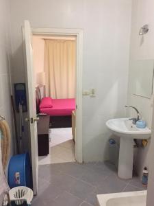 a bathroom with a sink and a pink bed at Cool Studio at nice resort with pool view in the heart of hurghada in Hurghada