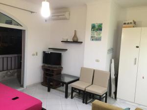 a living room with a table and chairs and a tv at Cool Studio at nice resort with pool view in the heart of hurghada in Hurghada