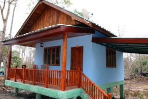 una pequeña casa azul con porche de madera en Soutchai Resort en Vientián