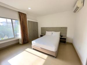 1 dormitorio con cama blanca y ventana en Hotel Zamay Plus, en Santa Marta
