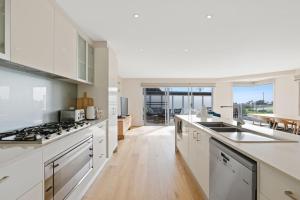 a kitchen with white cabinets and a counter top at Hazelwood in Cowes