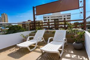 2 sillas blancas sentadas en un balcón en Hotel Zamay Plus, en Santa Marta
