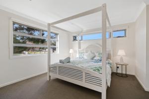 1 dormitorio con cama blanca y ventana en Hazelwood, en Cowes