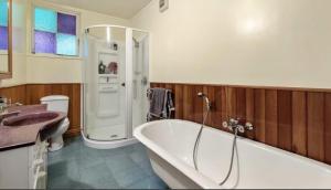 łazienka z wanną i umywalką w obiekcie Quiet secret garden Sun-trap w Auckland
