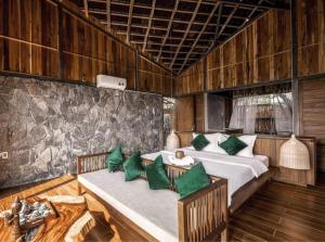 een slaapkamer met 2 bedden en groene kussens bij The Ruong Resort in Vung Tau
