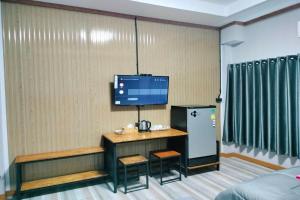 Pokój z biurkiem i telewizorem na ścianie w obiekcie Pingpong Place w mieście Ban Non Kum