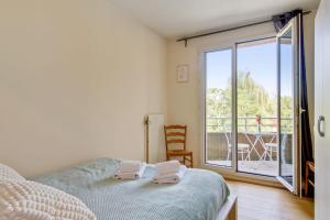 una camera da letto con un letto e due asciugamani di Bright one-bedroom in Villeneuve-d'Ascq - Welkeys a Villeneuve d'Ascq