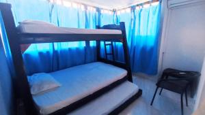 - une chambre avec 2 lits superposés et des rideaux bleus dans l'établissement Apartamento en lo mejor del Rodadero, à Rodadero