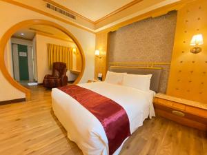 1 dormitorio con 1 cama grande y espejo grande en I Live Motel en Kaohsiung