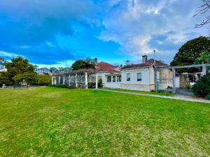 a house with a large lawn in front of it at Norman Lindsay Cottage in Faulconbridge