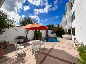ラパスにあるCasa Blancaのテーブルとパラソルとプールのあるパティオ