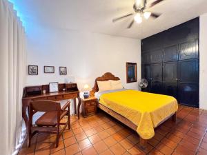 ラパスにあるCasa Blancaのベッドルーム1室(ベッド1台、黄色のベッドカバー付きデスク付) +28枚の写真