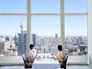 Tres mujeres sentadas en una mesa en una habitación con vistas en Sapporo Prince Hotel, en Sapporo