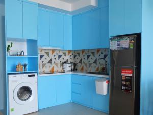 cocina azul con nevera y lavadora en Little Cloud Home Vũng Tàu - CSJ Tower en Vung Tau
