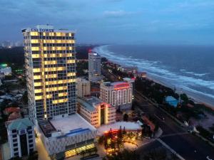 un edificio alto al lado del océano por la noche en Little Cloud Home Vũng Tàu - CSJ Tower en Vung Tau