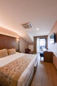 a hotel room with a large bed and a desk at İstport Hotels in Arnavutköy